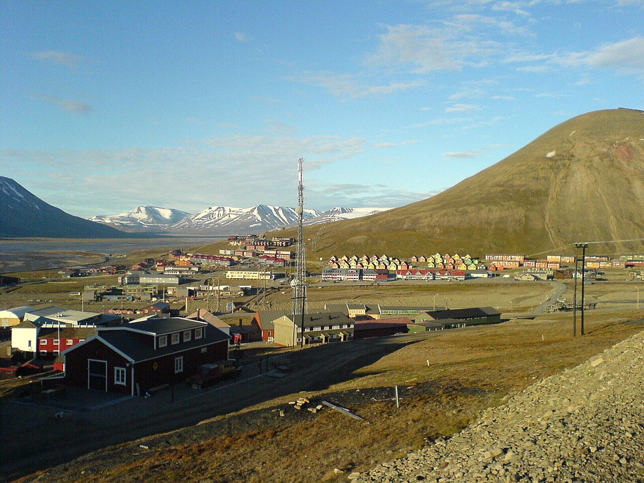 Colourful houses of Longyearbyen at the foot of a bare mountain on a clear day