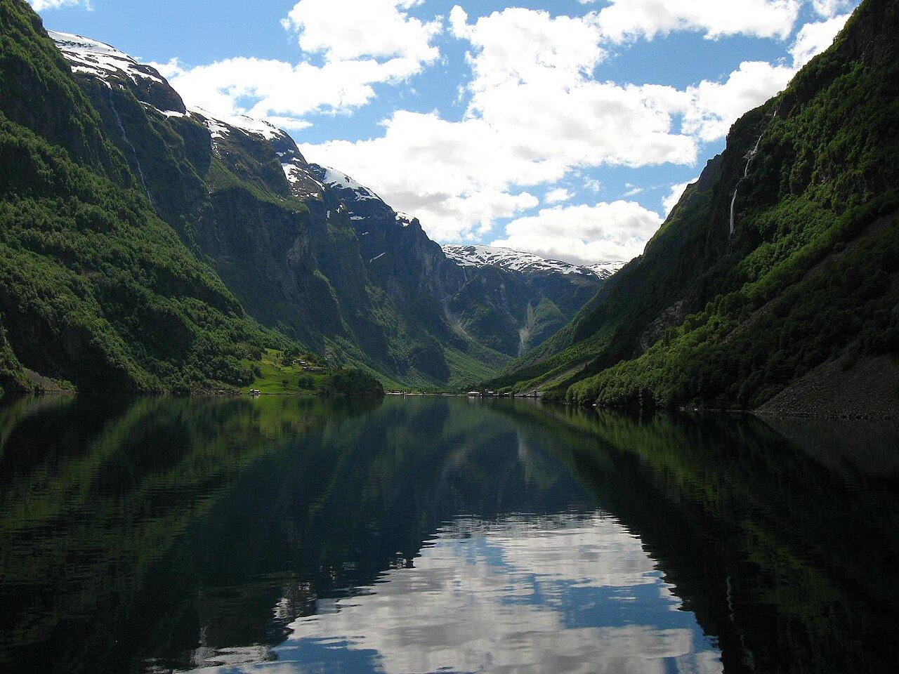 Mirror-still Nærøyfjorden between steep green walls, looking toward Gudvangen
